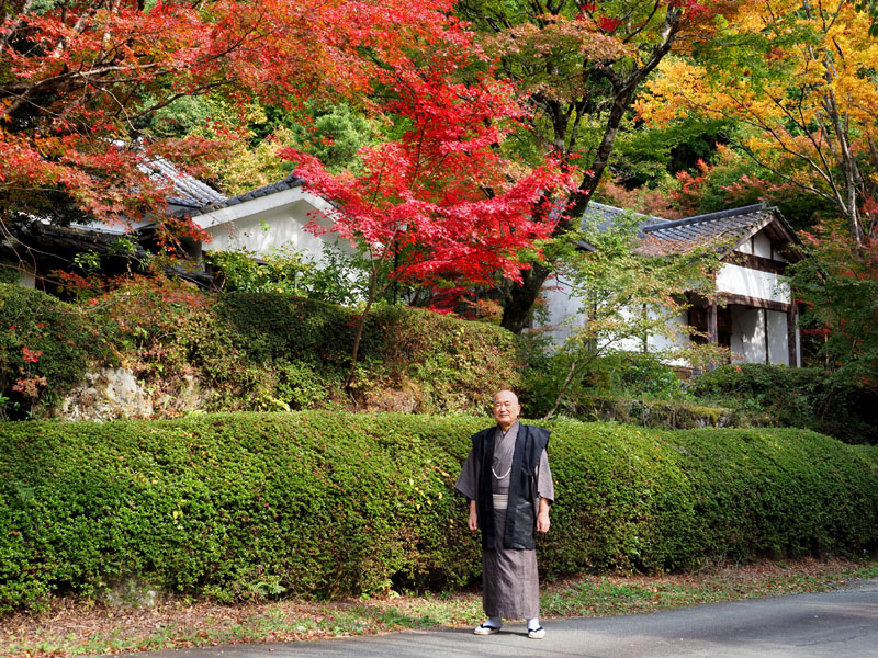 緑と紅葉に囲まれた伊佐邸と着物姿の和田爺
