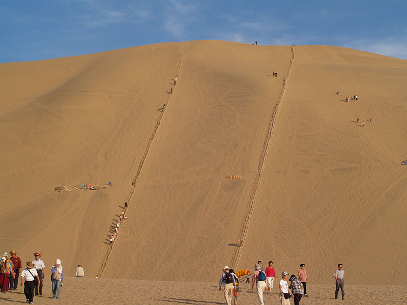 巨大な砂山を登る人たち