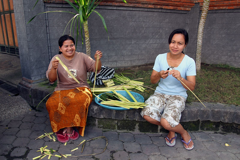 椰子の葉をナイフで削いでチャナンの籠を作る女性たち