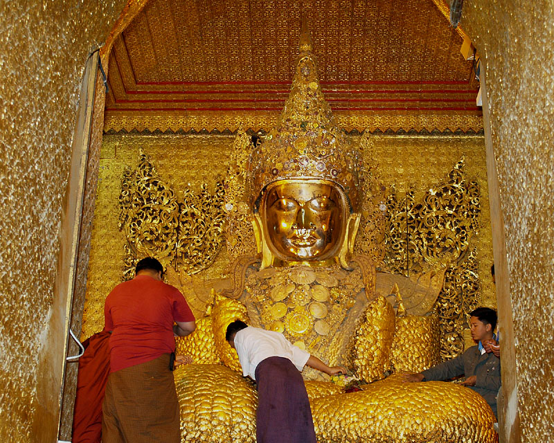 仏陀に金箔を貼る信者たち