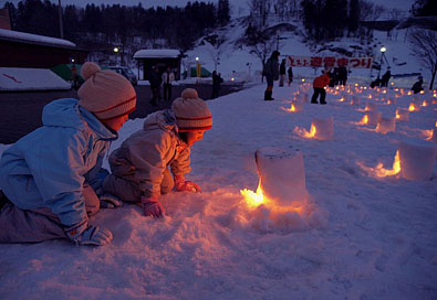雪で作った燈籠を覗き込む兄妹
