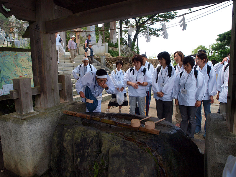 手水舎で手水の作法を指導する須崎祭事部長