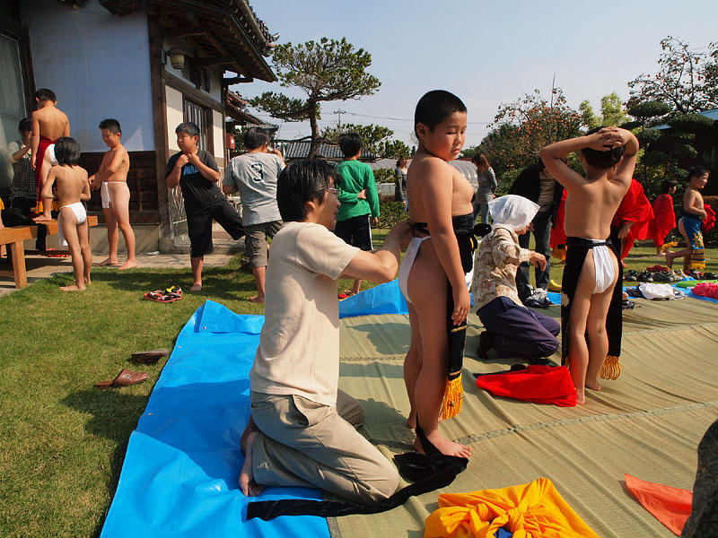 行司宿・磯野家の前庭で化粧廻しを身につける子供たち